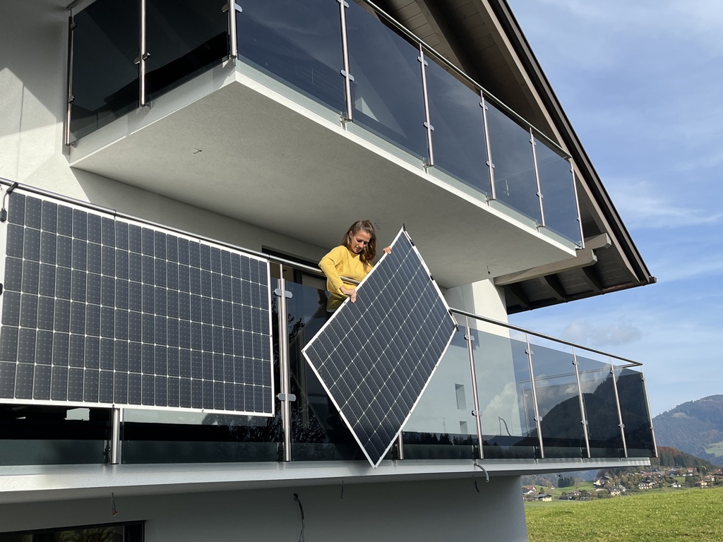 Lady putting solar panels on her balcony