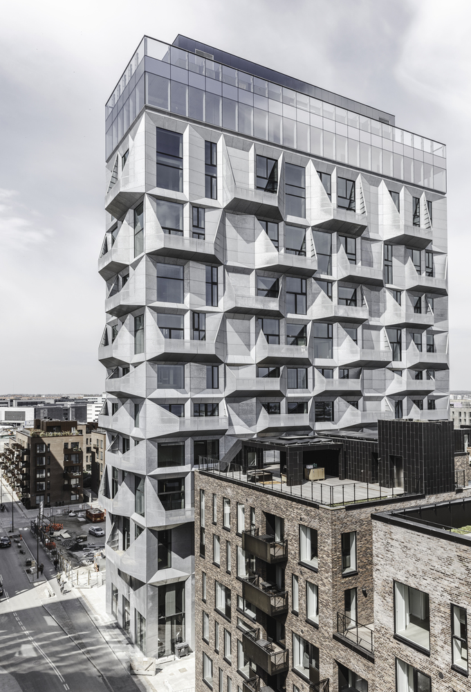 Old brutalist grain Silo in Copenhagen. Freshly clad and repurposed as an office building with grey metal panels.