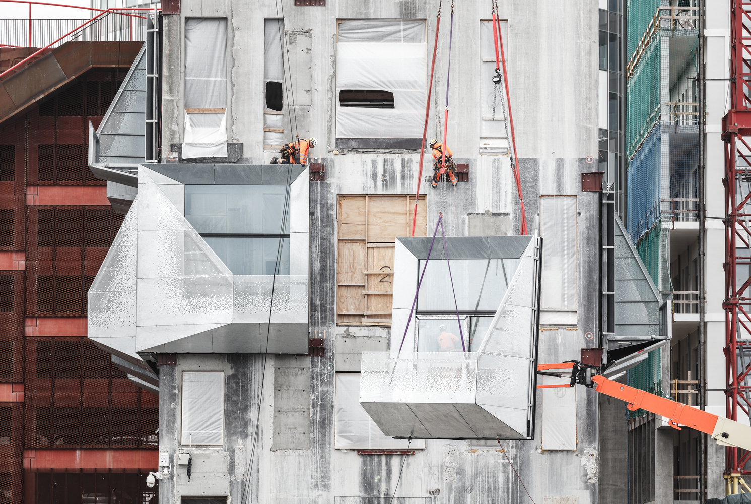 Old brutalist grain Silo in Copenhagen. Freshly clad and repurposed as an office building with grey metal panels. Under construction image.